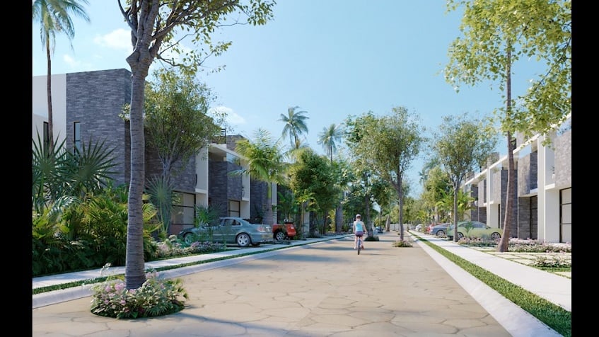 Fachadas de casas a la calle y un niño en bicicleta en Downtown de Tulum