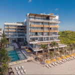 Fachada frente al mar y alberca en The Fives Oceanfront