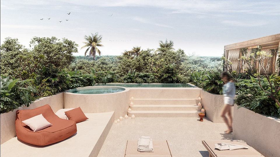 Penthouse terraza con vista a la selva con alberca y jacuzzi y una mujer de pie en Aflora Tulum