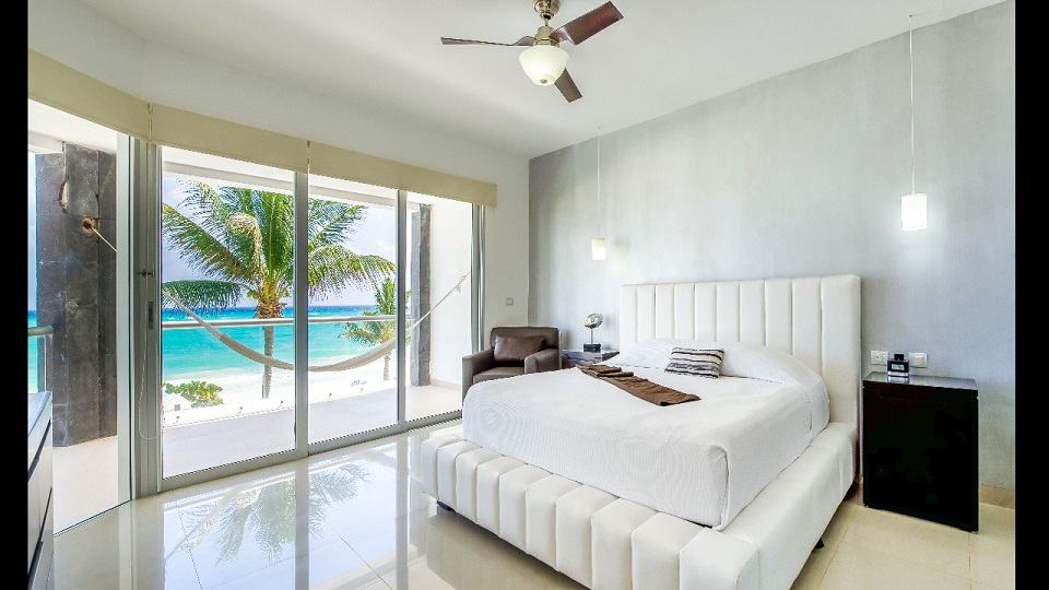 Dormitorio con hamaca en la terraza y vista al mar en Mareazul Beachfront Residences