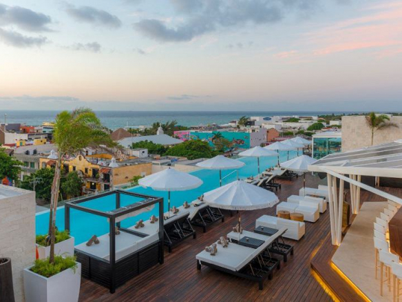 Azotea con piscina larga y bar con vista al mar en The Fives Downtown