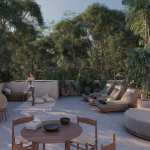 Salón rodeado por el jardín y una mujer haciendo yoga en Koh Apartments