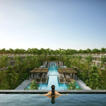 Piscine sur le toit et une femme dans l'eau regardant la piscine du rez-de-chaussée entourée de bâtiments résidentiels à Awa Playacar Residences