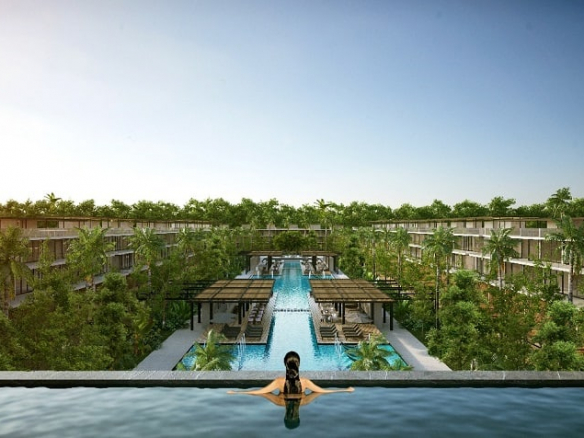 Piscina en la azotea y una mujer en el agua mirando la piscina de la planta baja rodeada de edificios residenciales en Awa Playacar Residences