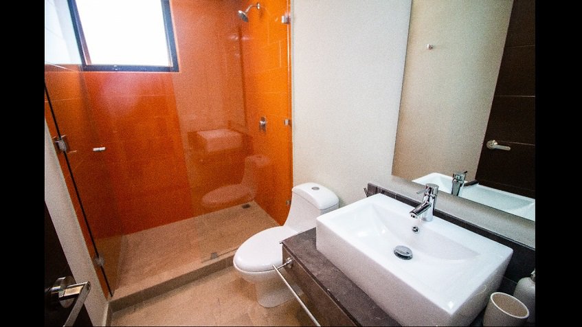 Baño con cabina de ducha de azulejos naranjas en Aleda Playa