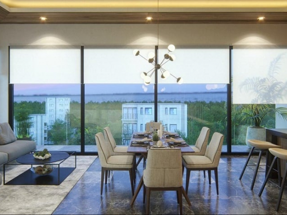 Interior de condominio estudio con esquina de pared de vidrio, sofá y mesa de comedor grande en Musa del Carmen