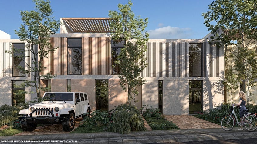 Two-story building facade with tall, narrow windows and parking lot in front in Edena Tulum