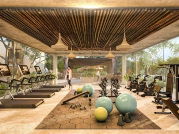 Large indoor gym with glass walls and jungle views Ophelia Tulum