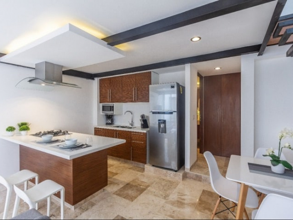 Cocina con una campana sobre una estufa en la parte superior de la isla en Zilha 42 Condominio