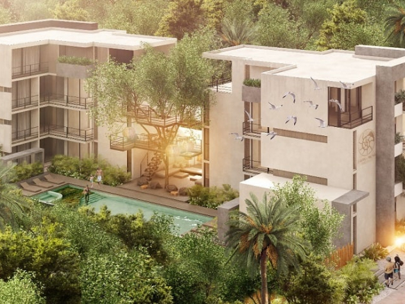 View of the pool between two white residential buildings at Villas Jardin Caracol Tulum
