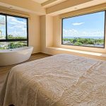 Baignoire dans une chambre, porte ouverte sur une salle de bain à Areia Playa del Carmen