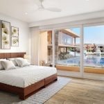 Chambre avec peintures florales au-dessus du lit king-size et mur de verre au Club Aqua Puerto Aventuras