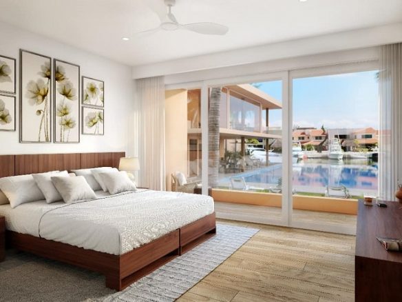 Recamara con cuadros de flores sobre la cama king size y la pared de vidrio en Club Aqua Puerto Aventuras