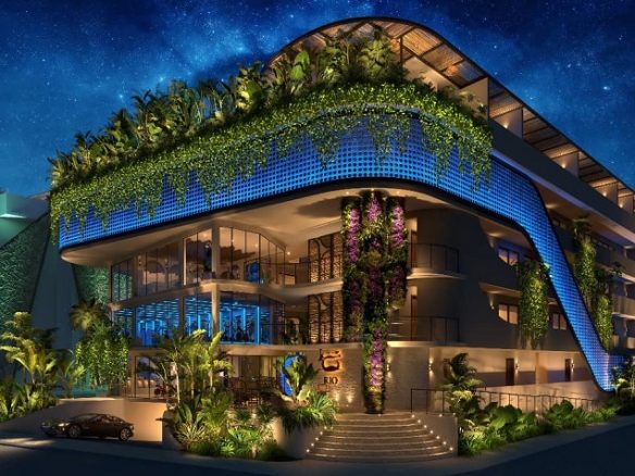 Fachada del edificio de propiedad rodeada de vegetación en Rio Aldea Zama