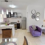 Cocina con barra desayunadora blanca y escalera junto al sillón violette en Valldemossa
