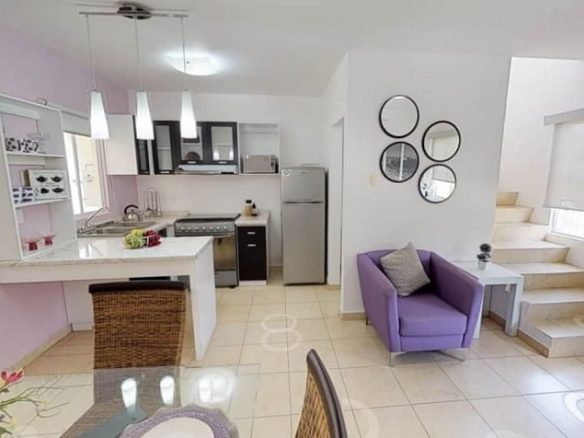 Cocina con barra desayunadora blanca y escalera junto al sillón violette en Valldemossa