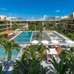 Overhead view of a pool, massage beds, and palm trees at Mistiq Premium Tulum