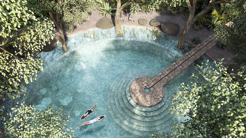 Vista superior de la piscina redonda en el jardín y dos mujeres nadando en Beecheii