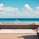 Piscine sur le toit avec une femme à l'intérieur regardant l'océan au Vibbe Luxury Condos