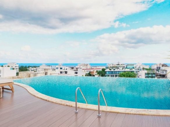 Rooftop pool and sundeck with city and ocean views at Green Savage