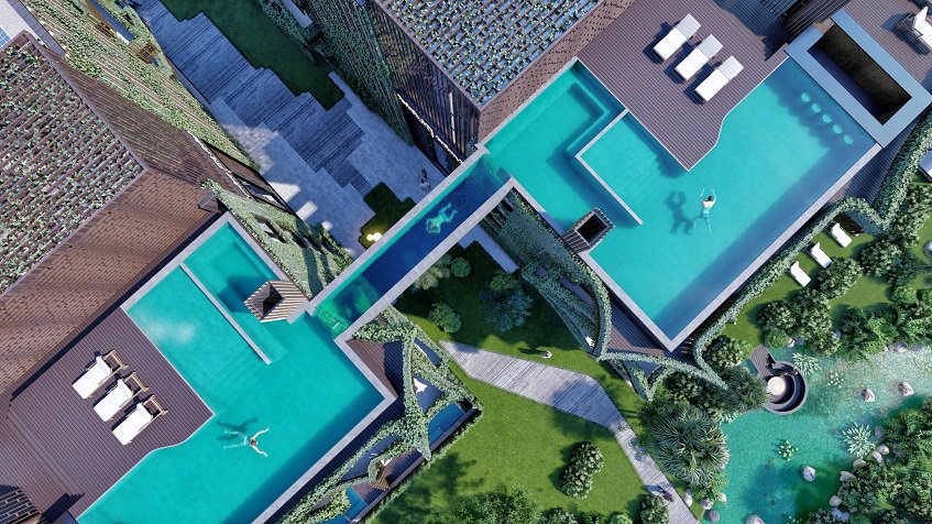 Piscinas en la azotea en la parte superior de dos edificios residenciales conectados con otra piscina con fondo de cristal en el distrito de Amira