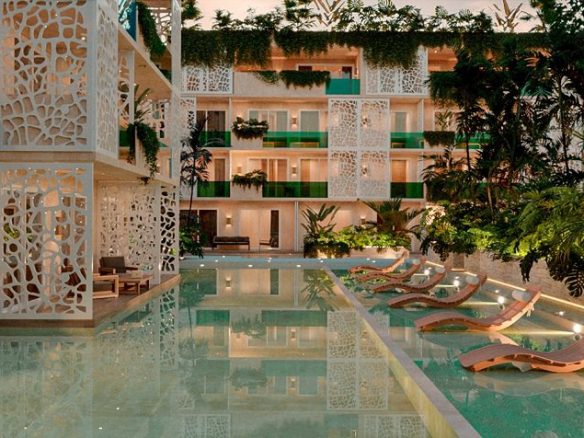 Jardín de alberca junto a edificio residencial en Ocean Tulum