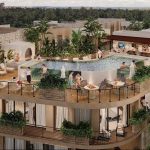 Fachada de edificio residencial con piscina en la azotea, bar y gente dando vueltas en Solum Tulum