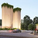Car passing by the two towers with the plant-covered roofs at Dharma Tulum