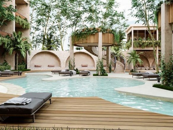 Pool and solarium surrounded by residential building and vegetation at Loch Tulum