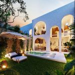 Jardín de la piscina de una casa durante la noche en Domum Tulum