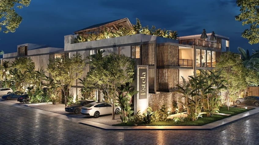 Edificio residencial y estacionamiento de autos por la noche en Estela Tulum