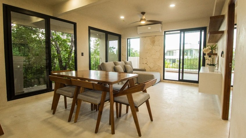 Sala con mesa de comedor y tres ventanas altas, terraza en esquina en Kantuun Tulum