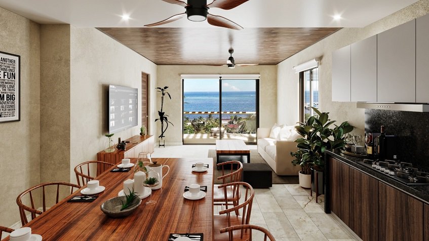Larga mesa de comedor de madera junto a la cocina y terraza con vista al mar en Porto Blu Puerto Morelos