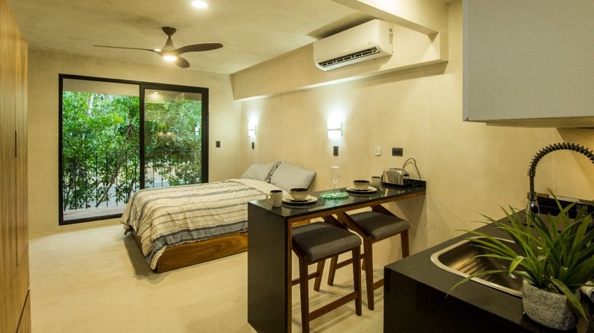 Interior de estudio, cama junto a una pequeña cocina en Kantuun Tulum
