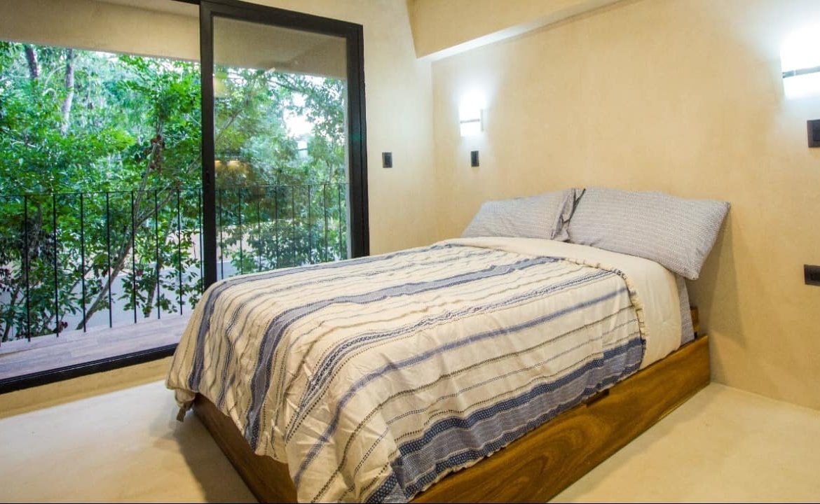 Recámara con balcón y vista al jardín en Kantuun Tulum