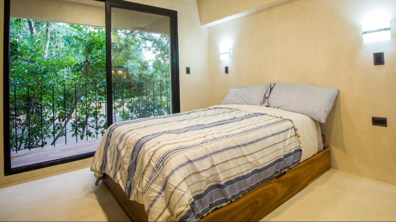Recámara con balcón y vista al jardín en Kantuun Tulum