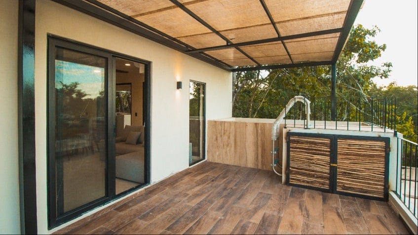 Terraza cuadrada y puerta ventana corrediza a la sala de estar en Kantuun Tulum