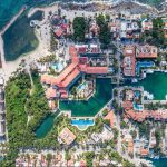 Vue aérienne d'un quartier résidentiel avec piscines en bord de mer et jetée au bord de l'océan à Secret Waters