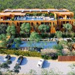 Aerial view of a residential complex with two pools and parking in Kune Tulum