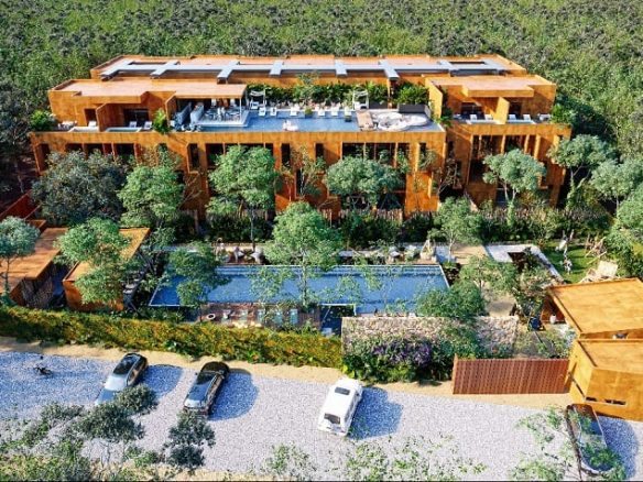Aerial view of a residential complex with two pools and parking in Kune Tulum