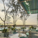 Restaurant and bar next to a pool surrounded by vegetation at Altra Beach Condos