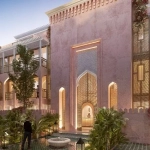Façade de style arabe d'un immeuble résidentiel, parking, homme debout sur un balcon, végétation au Pink Riad Tulum