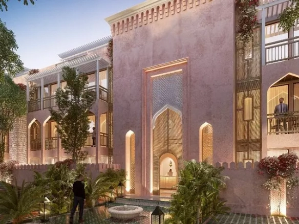 Arabian-style front facade of a residential building, parking lot, man standing on balcony, vegetation at Pink Riad Tulum