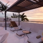 Deck de camastros, vista al mar durante un atardecer en Sur 307 Condominios