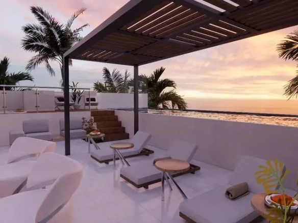 Deck de camastros, vista al mar durante un atardecer en Sur 307 Condominios