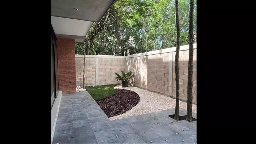 Terraza de una casa con dos árboles rodeada por un muro en Mayakoba House