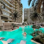 Piscine, bar et personnes dans l'eau, façade d'un immeuble résidentiel avec balcons à Valle Aurora, Cancun