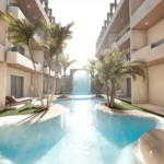 Piscina larga entre dos edificios residenciales en Cocay Lofts Tulum