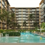Splash pool y piscina rodeada de sombrillas, camastros y palmeras, edificio residencial en Origin by Wolf Cancun