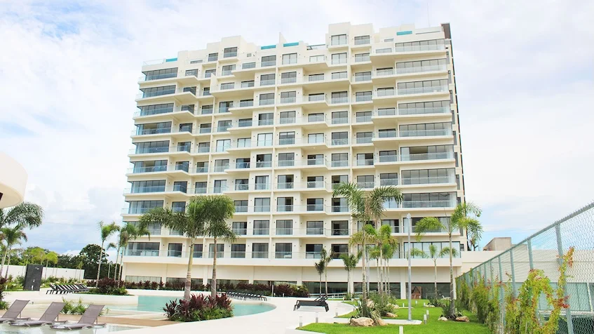 Fachada lateral con palmeras Valle Aurora Cancun